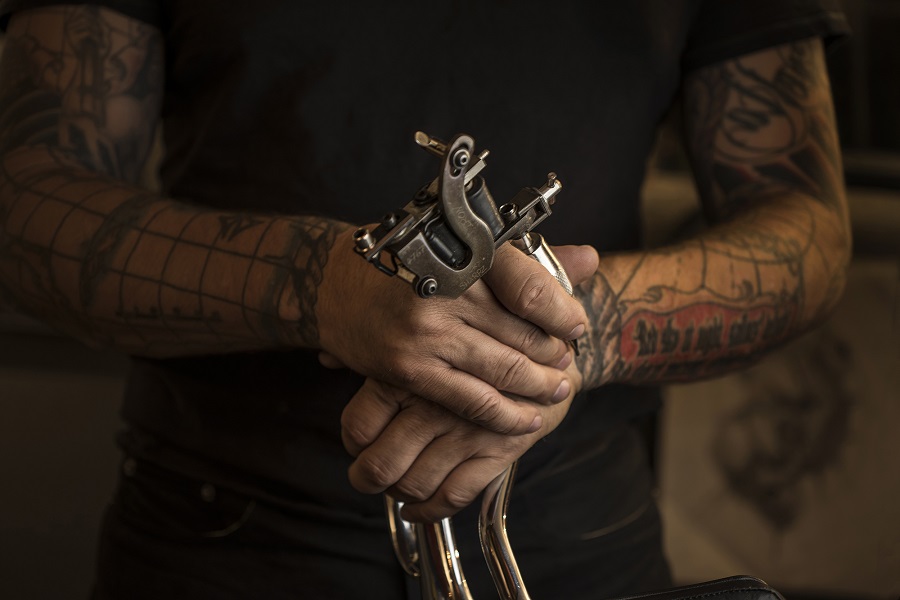 Speakeasy tattoo artist demoing tattoo tools
